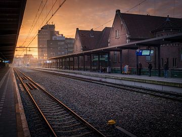Het centraal station van Deventer tijdens een zonsopkomst met mensen. van Bart Ros
