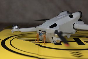 Der Miniaturfigurenmann legt eine neue SIM-Karte in die Drohne ein, um Fotos und Videos zu speichern