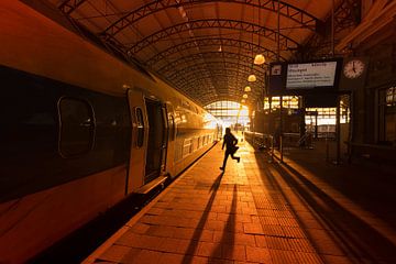Man runs to catch train at Hollands Spoor Station by Rob Kints
