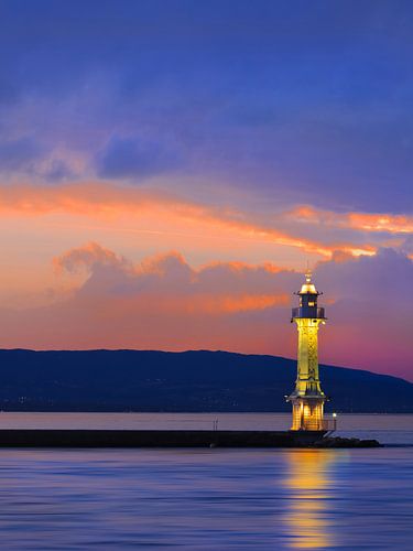 Antique lighthouse with multicolored sunset 