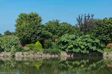 Üppiger Garten und Teich im Chateau de Gratot in Frankreich