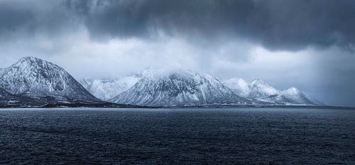 De besneeuwde bergen omringen het rustige water van Fiskebol in de Lofoten, 