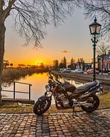 Motorcycle at picturesque harbour at sunset