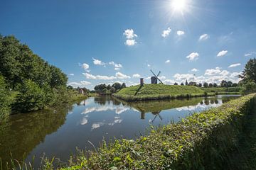 Bourtange Old Dutch Village wit a dike and a mill.