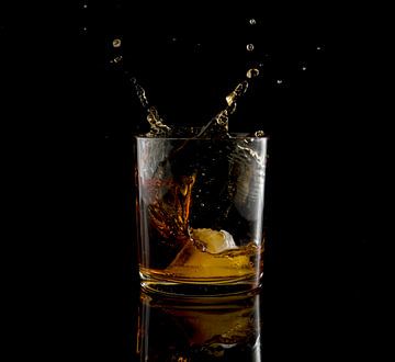 fallende Eiswürfel in einem Glas Whisky von ChrisWillemsen