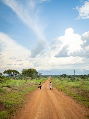 Frauen auf einer unbefestigten Straße in Uganda von Teun Janssen