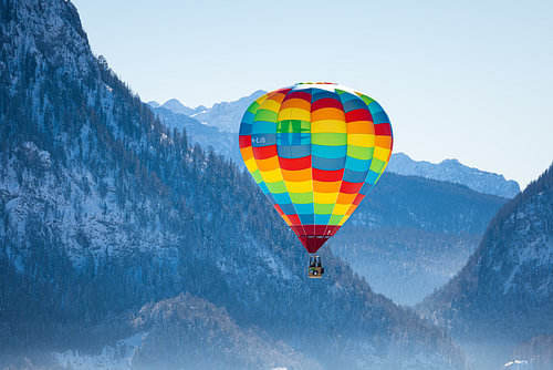 Heteluchtballonnen sieren de lucht boven een besneeuwd Inzell in Duitsland