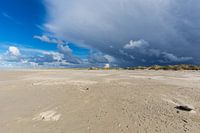 Sandy beach under a stormy blue sky in The Netherlands