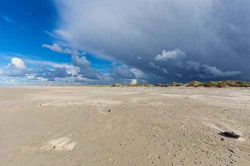 Sandy beach under a stormy blue sky in The Netherlands