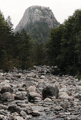 Bergwand boven een rotsachtige rivierbedding — Verticale landschapsfoto van Scandinavië