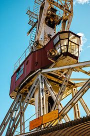 Grue portuaire à cabine vitrée – acier, patine & ciel bleu | art mural industriel sur Studio Grille-Pain – Création Photo