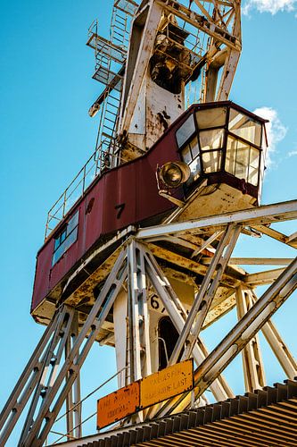 Havenkraan met glazen cabine – staal, roest & blauwe lucht | industriële fotokunst