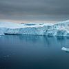 Majestätischer Eisberg unter dunklem Himmel von Chris Stenger