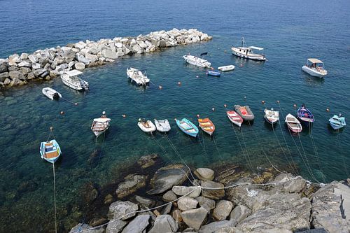 leisure boats in a rocky natural harbour in the mediterranean sea in italy, aerial view from above
