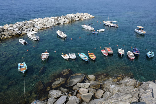 freizeitboote in einem felsigen naturhafen im mediterranen meer in italien, luftaufnahme von oben