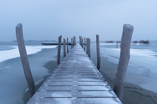 een steiger in het water in de winter.