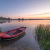 Red rowing boat at sunrise by Moetwil en van Dijk - Fotografie