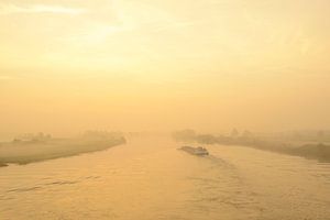 Ship in a sunrise over the river IJssel