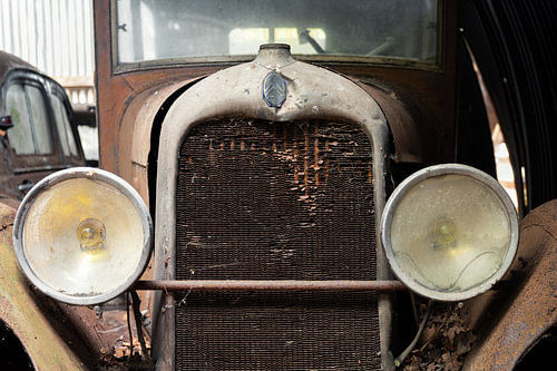 Verlassener Oldtimer mit rostigem Kühlergrill