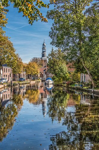Zicht op de kerktoren van Oldeboorn gespiegeld in de gracht