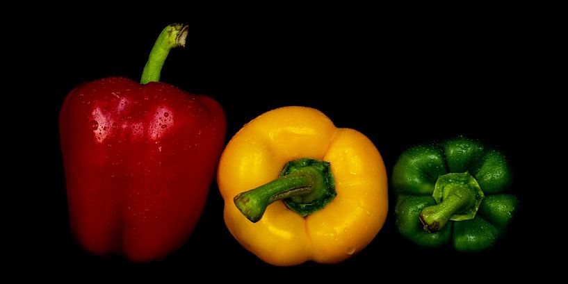 Macro verse paprika's met waterdruppels in kleuren rood geel groen tegen zwarte achtergrond van Dieter Walther