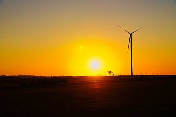 Wind turbine at sunset on a meadow by Martin Köbsch