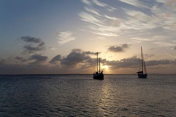 Zeilbootjes bij zonsondergang.