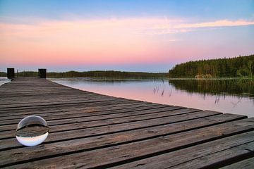 Glaskugel auf einem Steg der in einen See reicht von Martin Köbsch