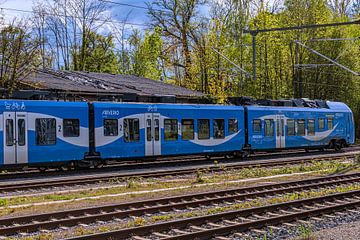 Een blauwe trein op het spoor van Photoart-Naegele