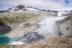 Sommerliche Berglandschaft in der Schweiz mit grünen Almen und markanten Gipfeln.