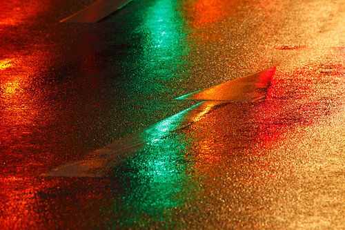 Flèche directionnelle rouge-vert sur la route sous la pluie