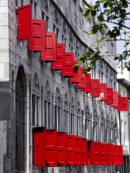 Volets rouges sur un bâtiment gris par Hannon Queiroz