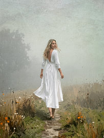 Charmante Frau in einem weißen Kleid in einer nebligen Landschaft von STUDIO ARTSY