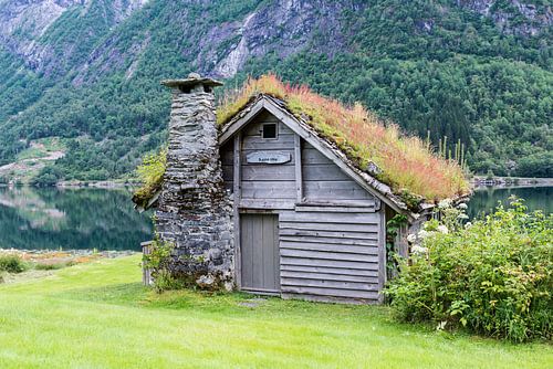 old fairytale like house of wood with chimney of stacked slate  