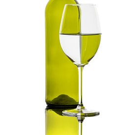 Reflecties van een gekleurde fles in een wijnglas van Roland Brack