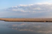 Wolken und Reflexionen am Strand im Abendlicht