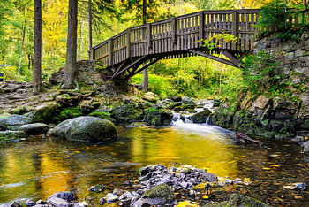 Holzbrücke über die Oker mit großen Steinen am Engagemen
