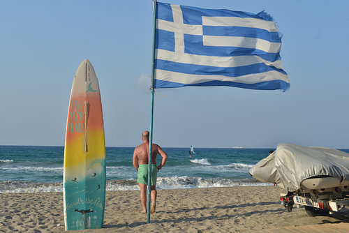Greek flag at Amoudara beach, a popular spot for surfers on the island of Crete