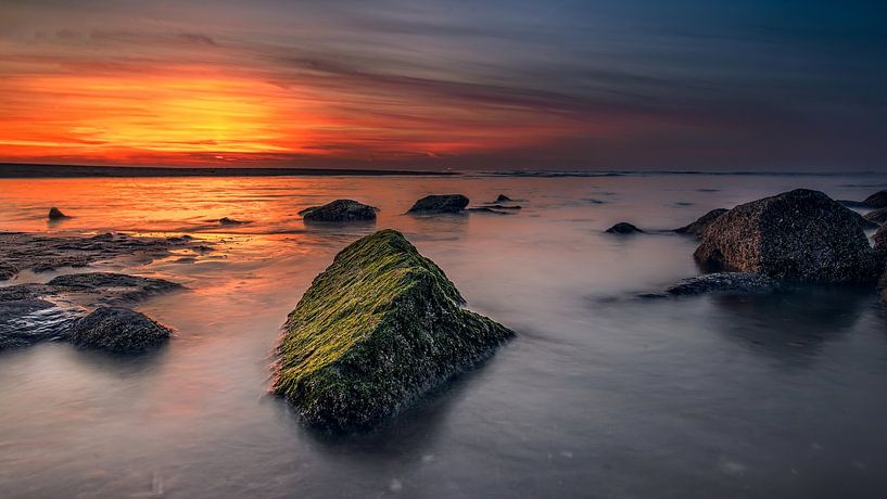 Rocks in the sea with setting sun by RICHARD Degenhart