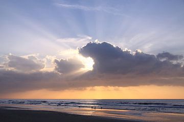 Sunset at the beach with clouds and rays of sunlight