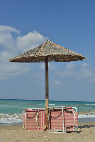 Strandliege und Sonnenschirm am kretischen Strand von Amoudara