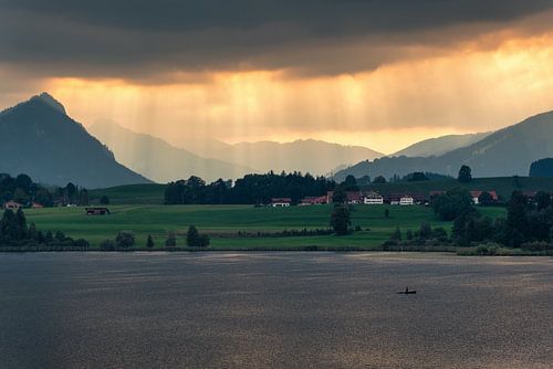 Zonnestralen boven de Hopfensee in het Allgäu