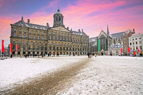 Besneeuwde Dam in Amsterdam bij zonsondergang in Nederland