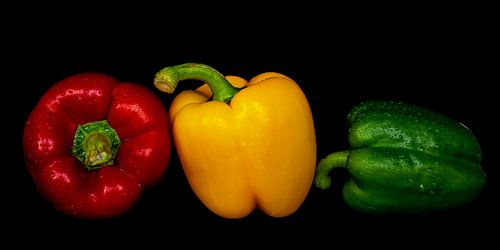 Macro verse paprika's met waterdruppels in kleuren rood geel groen tegen zwarte achtergrond