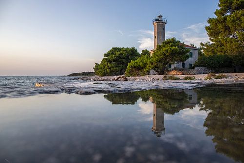 Landschap met zonsondergang, vuurtoren en dennenbos. Vir, Dalmatië, Kroatië