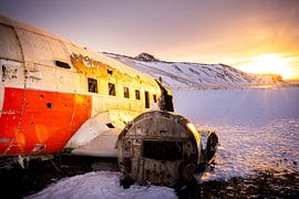 Wrack einer DC-3 in einer verschneiten Landschaft bei Sonnenuntergang, Eyvindarholt, Island von René Wiegmink