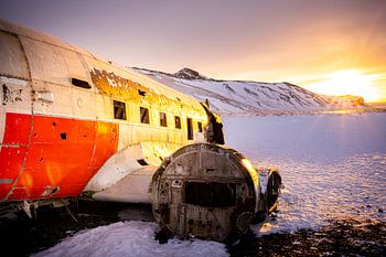 DC-3 vliegtuigwrak in besneeuwd landschap bij zonsondergang, Eyvindarholt, IJsland