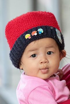 Enfant avec un chapeau de glace en Indonésie sur Anne Ponsen