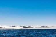 Sea mist between the rocky coast near Aasiaat, Greenland by Martijn Smeets thumbnail