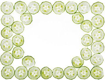 Schijfjes van komkommer op een witte achtergrond